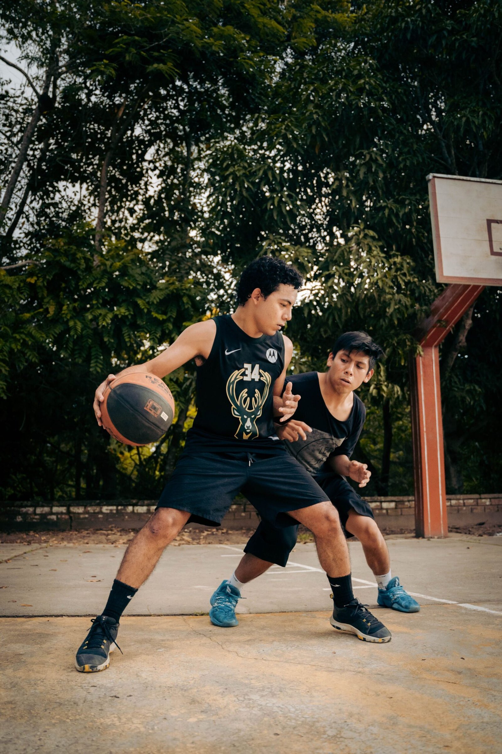 Two young men playing an intense game of basketball outdoors in Rioja, Perú.